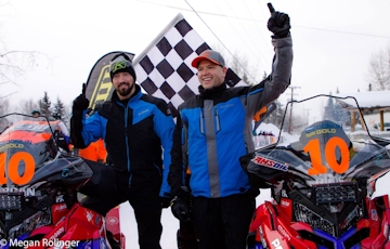 Mike Morgan and Chris Olds celebrating victory next to their wrapped sleds